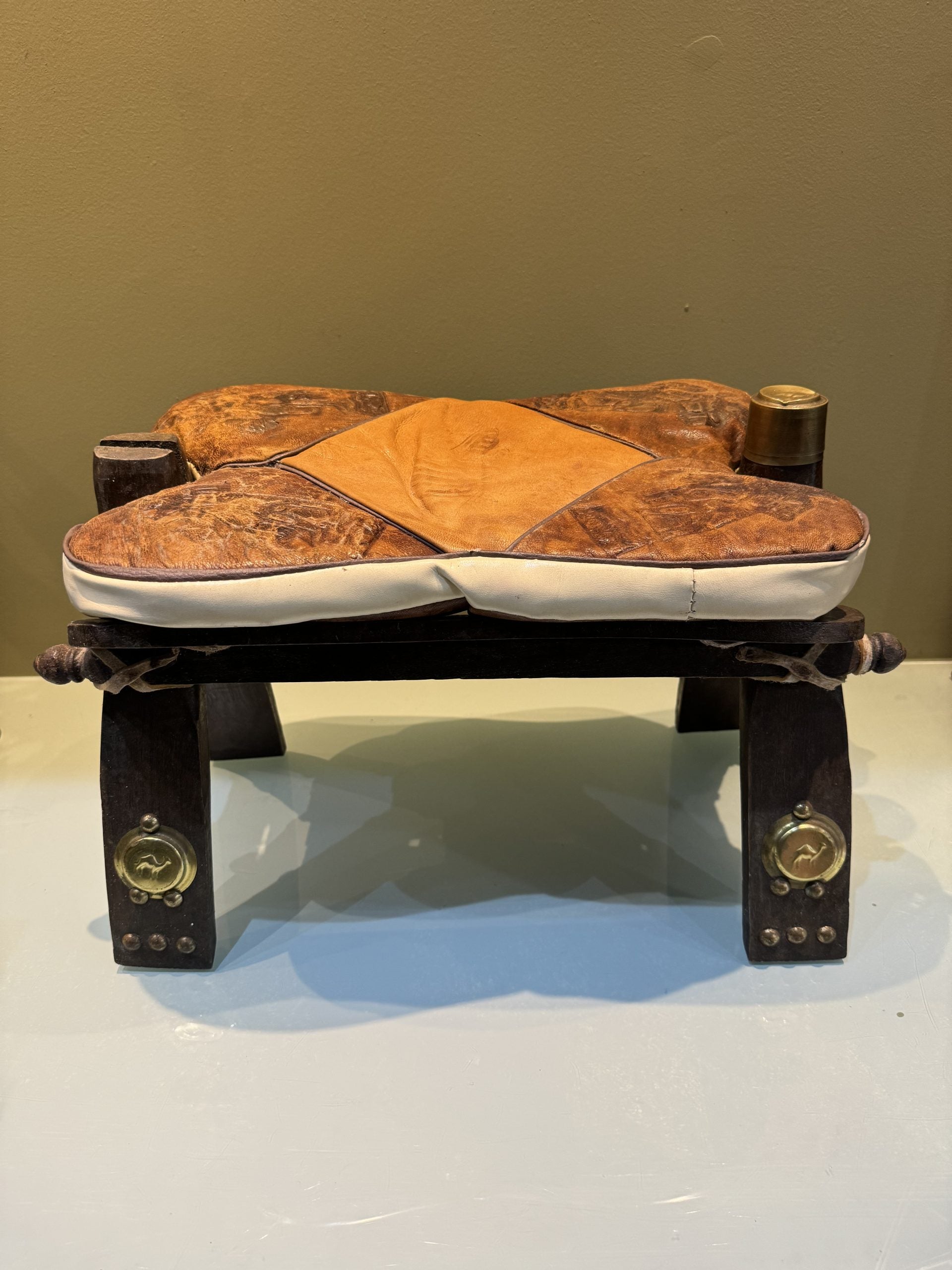Egyptian stools, camel saddles in wood, leather and brass